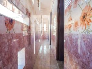 a hallway with flowers painted on the walls of a building at Hotel O KS ELITE in Pasumalai
