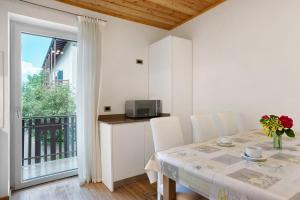 Un comedor con una mesa con sillas y un balcón. en Agritur Montibeller Fravort, en Marter di Roncegno