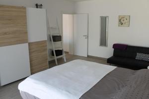 Un dormitorio con una cama grande y una silla negra. en Apartments Mala, en Cavtat