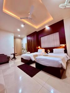 a bedroom with three beds and a ceiling at Rest Inn Hotel in Jāmb