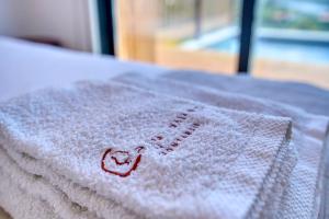 a white towel with a heart on it on a table at Caju Villas Montargil - Villa Terra Preta in Montargil +32 photos