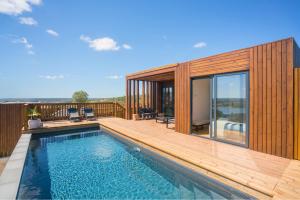 a house with a swimming pool and a wooden deck at Caju Villas Montargil - Villa Terra Preta in Montargil