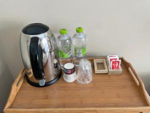 una macchina per il caffè e bottiglie d'acqua su un vassoio di legno di Next Stop Vatican Guest House a Roma