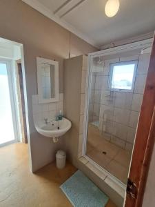 a bathroom with a sink and a shower at Haus Windhoek - Charming Coastal Escape in Struisbaai +43 photos
