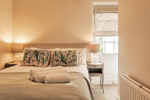 a bedroom with a bed and a desk and a window at Finest Retreats - Hendy Cottage in Stroud