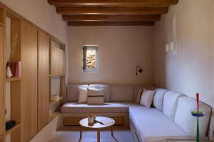 a living room with a white couch and a table at Mousti's Cell in Serifos Chora