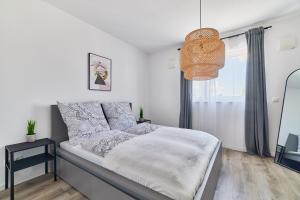 a bedroom with a bed and a pendant light at ELA Apartments Mannheim in Mannheim