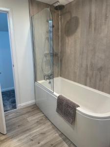 a bathroom with a shower and a white tub at Casa Sands in Spittal +11 photos
