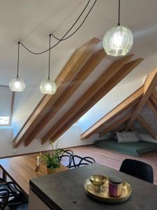 a room with wooden ceilings and a table and lights at NOSTALGIE BOUTIQUE Suite in Brno