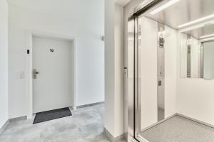 a hallway with white walls and a glass door at ELA Apartments Mannheim in Mannheim +99 photos