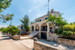 an old stone house with a staircase on a street at Holiday home in Supetar in Supetar