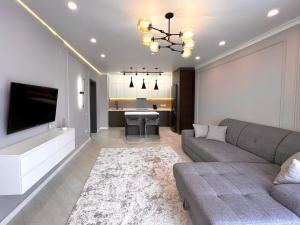 Una sala de estar con un sofá y un televisor. en Новая Раимбек Резиденс 13-65 & питьевая вода в подарок, en Almaty 9 fotos más