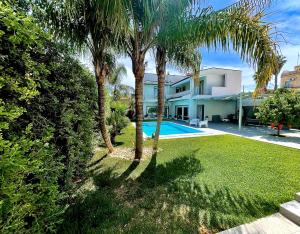 a house with a swimming pool and palm trees at Angolo paradiso in Castelvetrano Selinunte