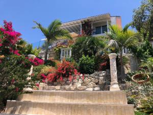 un jardín frente a una casa con flores en Villa Daria Kamares Tala Luxury Sea View, en Pafos