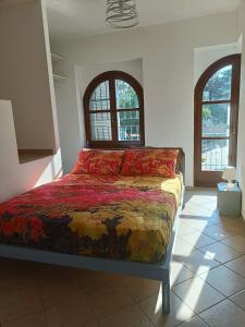 a bedroom with a bed in a room with two windows at La Casa del Merlo in Rodello
