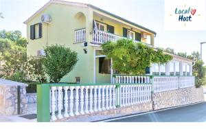 a house with a white fence in front of it at Apartment Pelicaric Sali Dugi otok in Sali