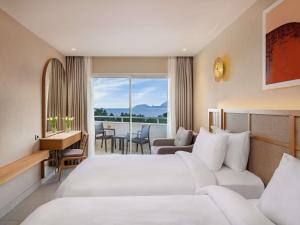 a hotel room with a bed and a couch at Rixos Premium Tekirova - The Land of Legends Access in Tekirova