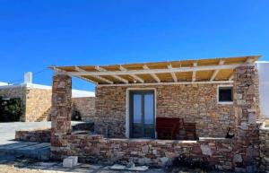 a stone house with a wooden roof at Rustic Stone House in the Heart of Folegandros in Áno Meriá