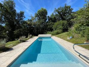 a blue swimming pool with a bench on the side at La villa Hortense in Valençay