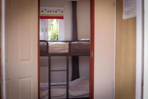 Fenced Backyard with Covered Porch and Free Bikes في Doornspijk: باب يؤدي إلى غرفة مع سرير بطابقين