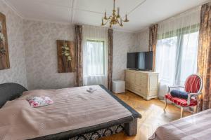 a bedroom with a bed and a television and a chair at Baltic Holiday Guest House in Jūrmala