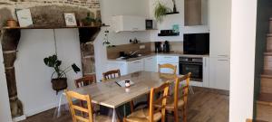 a kitchen with a wooden table and chairs at Chez Henri in Les Herbiers