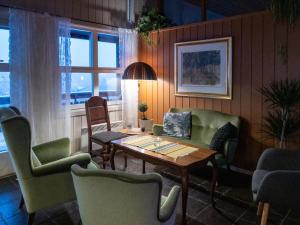 a living room with a table and chairs and a window at Malmplassen Bed & Breakfast in Tolga