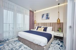 ein Schlafzimmer mit einem großen Bett und großen Fenstern in der Unterkunft Jupiter Hotel in Odessa