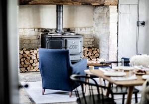 une cuisine avec une cuisinière, des chaises et des tables dans l'établissement River Cottage HQ, à Musbury 17 autres photos