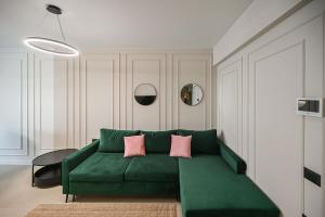 马马亚Rayan Apartment in Odyssey Spa Pool & Fitness-parking的客厅配有绿色沙发及粉红色枕头 更多36张照片