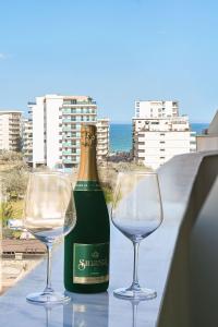 马马亚Rayan Apartment in Odyssey Spa Pool & Fitness-parking的一瓶葡萄酒和两杯酒