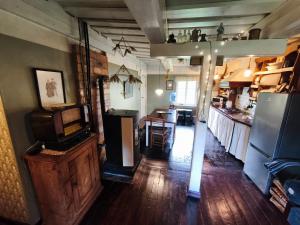 a living room with a tv and a kitchen at Vēsturiska viensēta Kārkliņi in Cēsis