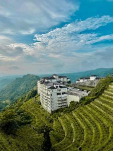 ein weißes Gebäude auf einem Hügel neben einem Weinberg in der Unterkunft Twinlakes Tagaytay 1BR in Laurel