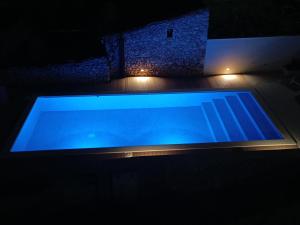 a large blue swimming pool in a dark room at Apartment Leni in Cres