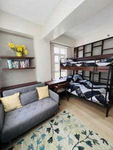 ein Wohnzimmer mit einem Sofa und Etagenbetten in der Unterkunft Twinlakes Tagaytay 1BR in Laurel