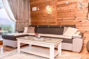 a living room with a couch and a table at Ostrog Wood House in Železnička Stanica Dabovići