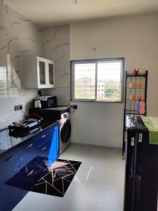a kitchen with a washing machine in a room at Miracle Stays Nashik-NEW 2BHK close to Sula and Trimbak in Nashik +8 photos