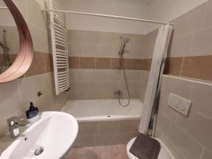 ein Badezimmer mit Badewanne, Waschbecken und Dusche in der Unterkunft Lakeside Heritage Apartment in Balatonfüred