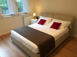 a bedroom with a large bed with two red pillows at Villa Miami Taormina in Taormina +18 photos