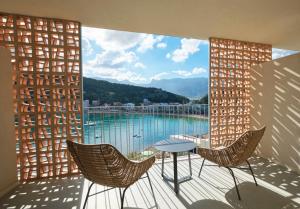 a balcony with chairs and a table and a view of the water at Salino Port Soller-Adults Only in Port de Soller