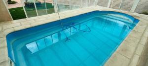 a large blue swimming pool with a hose in it at El Rincón in Gallegos