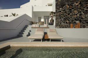 una casa con due sedie e una piscina di Grace Hotel, Auberge Resorts Collection a Imerovigli