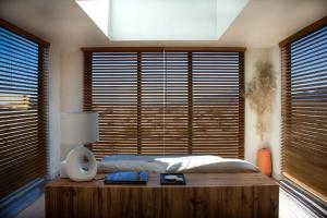a bedroom with a bed with a wooden table and windows at The Milky Way Cabin in Twentynine Palms