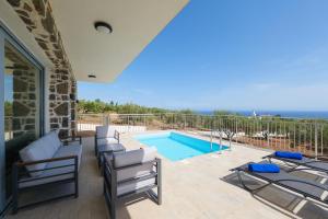 a patio with chairs and a swimming pool at Chryselia Suites- Private Pool in Keratokampos