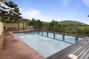 a swimming pool on a deck with a view of a mountain at Loup Blanc in Bouillante
