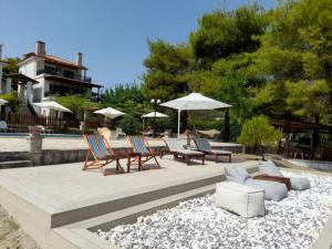 a patio with chairs and tables and umbrellas at Eternal Sunset Villa #1 in Pefkohori