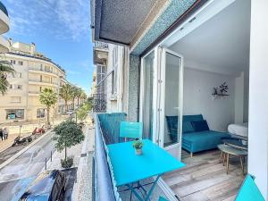 a balcony with a blue table and a couch at Studio proche gare, balcon in Cannes
