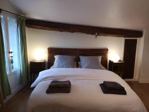 a bedroom with a large white bed with two pillows at Les Ombelles in Saint-Estèphe +13 photos