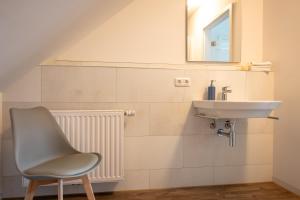 a bathroom with a sink and a chair at ErholungNOW-Haus in ruhiger Lage in Bispingen +39 photos