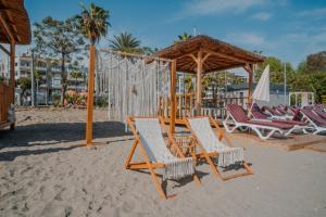 a group of chairs and a gazebo on a beach at Heritage by Cimen Hotel in Alanya